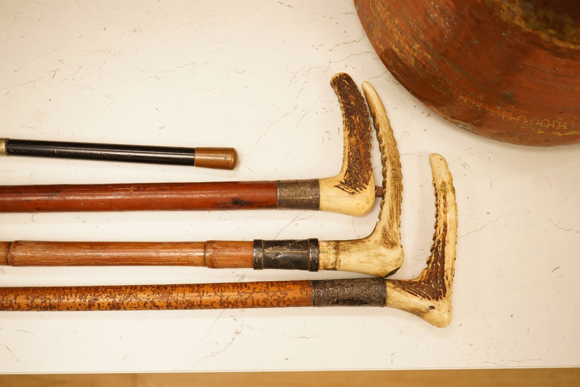 Three early 20th century antler handles riding crops with silver mounts and a swagger stick engraved Louise Martin, 1919